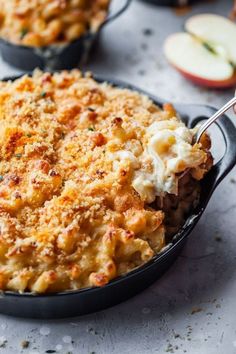 macaroni and cheese casserole in a cast iron skillet with an apple on the side