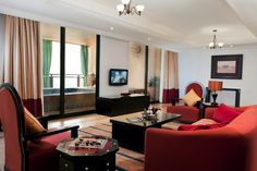 a living room filled with furniture and a flat screen tv mounted to the side of a wall