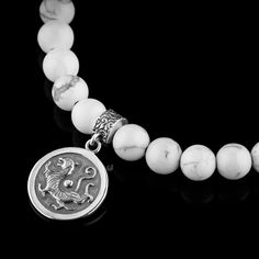 About Specifications Complete your outfit with our Howlite - White Tiger Bracelet (6mm). The bracelet is finished with a silver tiger bead & coin. Handcrafted in The Netherlands by professional artisans with the best Nature has to offer and finished with 925 Sterling Silver. - Gems: Howlite - Stone size: 6mm - Metal: 925 Sterling silver - Cord: High-end durable silicone - Packaging: Comes with a linen pouch. (Due to the unique characteristics of natural stone, the size and color of the beads can vary slightly.) White Howlite Bracelets With Natural Stones, Howlite Natural Stone Bracelet, White Howlite Bohemian Bracelet, White Howlite Bracelet, Hand-strung Round Howlite Beads Jewelry, Unique Opal, Howlite Stone, White Tiger, Jasper Stone