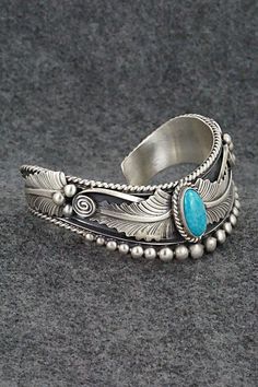 This beautiful turquoise and brushed-finish sterling silver bracelet featuring feathers was made by Navajo silversmith Tom Lewis. The back is signed R.B. and .925.Size: 5 1/2" (will fit up to a 6 5/8" wrist)Gap: 1 1/8"Width: 7/8"Free shipping on all orders! We ship with USPS and always include tracking. All orders ship within a day of payment.Returns are accepted up to 30 days after you receive your order. Just send us a message. Our shop offers cash back or store credit. The item must be returned in new condition. Tom Lewis, Bear Carving, Pearl Chain, Sterling Silver Bracelet, Native American Jewelry, Turquoise Sterling Silver, Free Jewelry, Sterling Silver Bracelets, Feathers