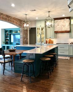 a large kitchen with an island in the middle and stools at the end,