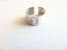 "Chinese letters ring, Happiness Ring, Chines symbol, adjustable Silver band ring, Personalized engraved Ring, inspirational & spiritual Ring. This ring has a Chinese symbol that means HAPPINESS ! I can engrave these Chinese symbol: LOVE, LUCK, LIFE, HAPPINESS This ring is made with aluminum with brushed finish. It has a unisex style so you can match rings. The ring is an open cuff adjustable design, and will best fit US sizes 6.25 through 7.25. Measurement: ** Ring width is about 0.45\" ** Symbolic Adjustable Engraved Open Ring, Symbolic Adjustable Open Midi Rings, Symbolic Adjustable Midi Rings, Adjustable Symbolic Open Midi Rings, Adjustable Symbolic Promise Rings, Meaningful Adjustable Open Ring, Adjustable Engraved Spiritual Ring, Adjustable Open Engraved Ring For Gift, Adjustable Open Ring With Meaningful Style