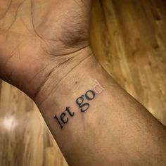 a wrist tattoo with the words let go written on it