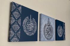 three canvases hanging on the wall with arabic calligraphy in blue and white colors