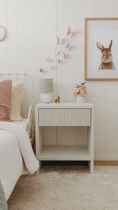 a bedroom with white walls and pink decor