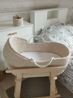 a wicker bassinet sitting on top of a wooden stand