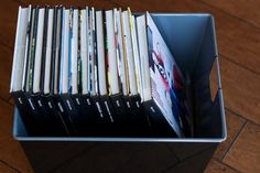 a metal container filled with books on top of a wooden floor