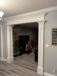 a living room with hard wood flooring and white columns