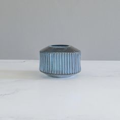 a blue vase sitting on top of a white counter