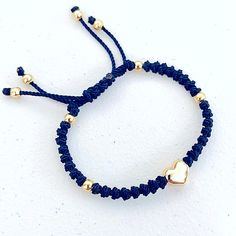 the bracelet has two hearts on it and is attached to a cord with gold beads