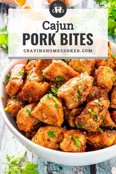 cajun pork bites in a white bowl with cilantro and parsley on the side