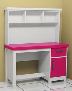 a pink and white desk sitting on top of a tiled floor next to a wall