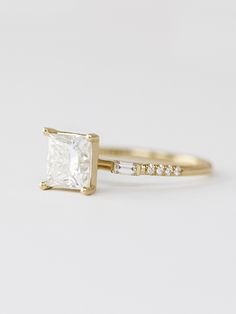 a gold engagement ring with a princess cut diamond