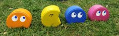 four painted rocks in the grass with eyes on them