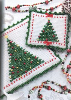 three christmas tree coasters on a table with beaded decorations and beads around them