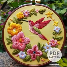 a hand embroidered hummingbird and flowers on a yellow background is featured in this embroidery pattern