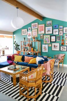 a living room filled with lots of furniture and pictures on the wall above it's coffee table