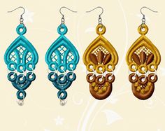 three pairs of earrings hanging from hooks on a white background with swirly lines and flowers