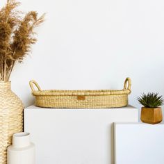 a wicker basket sitting on top of a white shelf