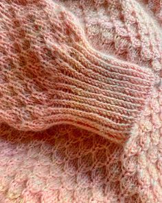 a close up view of a pink knitted sweater