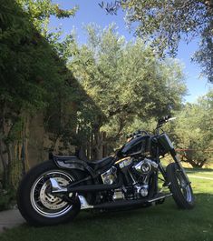 a black motorcycle parked on top of a lush green field