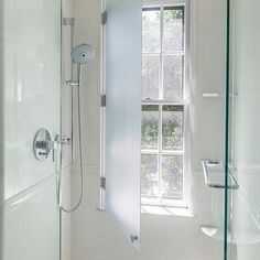 a bathroom with a walk in shower next to a window