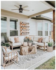 an outdoor living area with furniture and potted plants on the side of the house