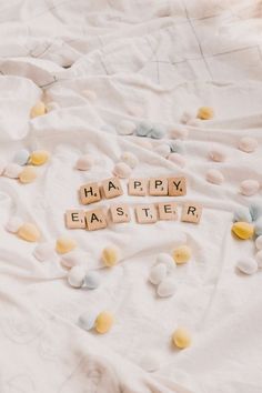 the word happy easter spelled with scrabbles on a bed