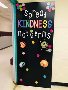 a black door with colorful magnets on it that says spread kindness not germs