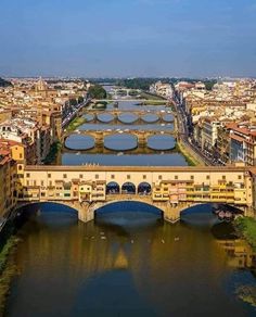 an aerial view of a bridge spanning the width of a river and buildings on both sides