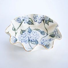 a blue and white flowered dish on a white background