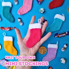 a person holding their hand in front of small christmas stockings and candy on a blue background