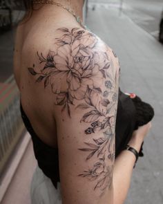 a woman with a flower tattoo on her shoulder