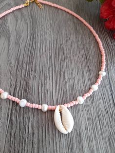 These lovely single strand beaded chokers/necklaces are great for adding a pop of colour.  Using coral coloured seed beads as well as beautiful freshwater pearls and a Cowrie shell They are finished off with a lobster clasp and a 5cm extension chain if you would like one. length of the choker is including the clasp and endings - This listing is for 1 necklace.  - Handmade in the UK - Made to Order Postage is done through Royal Mail 2nd class so no tracking available For International deliveries: Summer Beaded Shell-shaped Necklaces, Summer Shell-shaped Beaded Necklaces, Shell-shaped Beaded Pearl Necklace, Tiny Beads Shell Necklace For Summer Gift, Summer Shell Necklace With Tiny Beads As Gift, Round Bead Pearl Necklace For The Beach, Handmade Pearl Beaded Choker Necklace, Summer Shell Necklace With Tiny Beads For Gift, Summer Shell Necklace With Round Beads As Gift