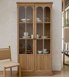 a wooden china cabinet sitting next to a wicker chair