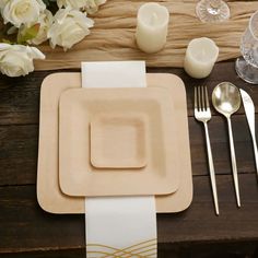 a place setting with white flowers and candles