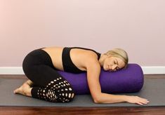 a woman laying on a yoga mat with her eyes closed