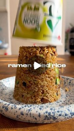 a stack of rice sitting on top of a blue and white plate next to a can of soda