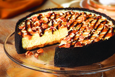 a chocolate cake with pecans and nuts on top is sitting on a glass plate