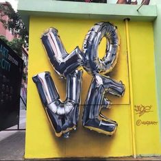 an image of some balloons that are in the shape of the word love on a wall