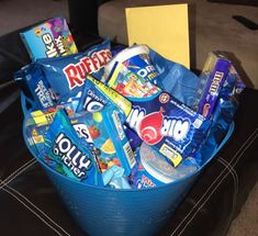 a blue bucket filled with candy and snacks