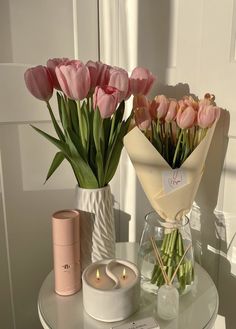 a woman is arranging pink flowers in a vase on a small table with an mp3 player