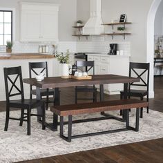 a kitchen table with four chairs and a bench