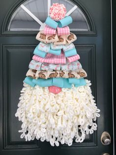 a door hanger made out of yarn with a christmas tree decoration on the front