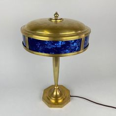 a blue and gold table lamp on a white background