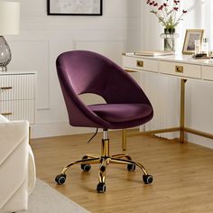 a purple office chair sitting on top of a wooden floor next to a white desk