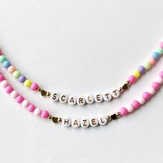 Add a burst of vibrant charm to your little one's outfit with our Bright Colorful Beads Name Necklace! This delightful piece combines the timeless elegance of dainty gold name beads with an array of eye-catching, colorful hued beads. Your child's name is spelled out in gold and adorned with a captivating spectrum of colors, creating a personalized gift that will surely bring smiles. This necklace would make a perfect birthday gift for little girls.  Perfect for Easter too! Colorful acrylic beads strung on wire and accented with Gold letter Beads, 18k plated heart beads and 18k plated gold ball beads. 18K gold hearts or 18K round ball beads.   Choose which style you would like from the drop down menu along with the length of the necklace. Necklace is packaged for gift giving. To see more Ki Cute Personalized Multicolor Charm Necklaces, Playful Pink Charm Necklaces For Friendship, Fun Pink Adjustable Charm Necklace, Playful Pink Charm Necklace For Friendship, Fun Pink Adjustable Charm Necklaces, Adjustable Multicolor Charm Necklace For Birthday, Pink Adjustable Fun Charm Necklace, Adjustable Multicolor Charm Necklaces For Birthday, Adjustable Colorful Beads Necklace For Birthday