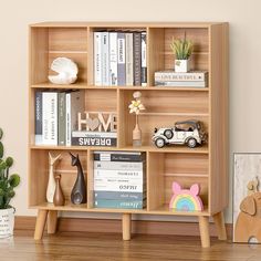 a bookshelf filled with lots of books next to a small potted plant