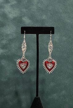 "Long Red Heart Evil Eye Halloween Witchy Earrings--Silvertone--Pagan Dangly Drop Earrings--Halloween Jewelry This is a long dangling earring.  These uniquely styled earrings have a filigree connector piece leading to a red enamel heart with a raised rose and an evil eye on the charm.  Halloween jewelry with Victorian style drop earrings for costumes, cosplay, LARP, Renaissance Faires, Witchy Coven meetings and Vampire Balls. Approximately 3 1/2\" inches long, yet with a slim, narrow profile. If Silver Gothic Earrings For Valentine's Day, Gothic Heart-shaped Pierced Jewelry, Handmade Gothic Jewelry For Valentine's Day, Gothic Metal Earrings For Valentine's Day, Nickel-free Dangle Heart Earrings For Festivals, Gothic Dangle Heart Earrings For Gift, Gothic Dangle Earrings For Valentine's Day, Vintage Silver Metal Heart Earrings, Nickel Free Heart Earrings For Festivals