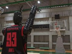 an inflatable man is playing basketball on the court with his hands up to the basket